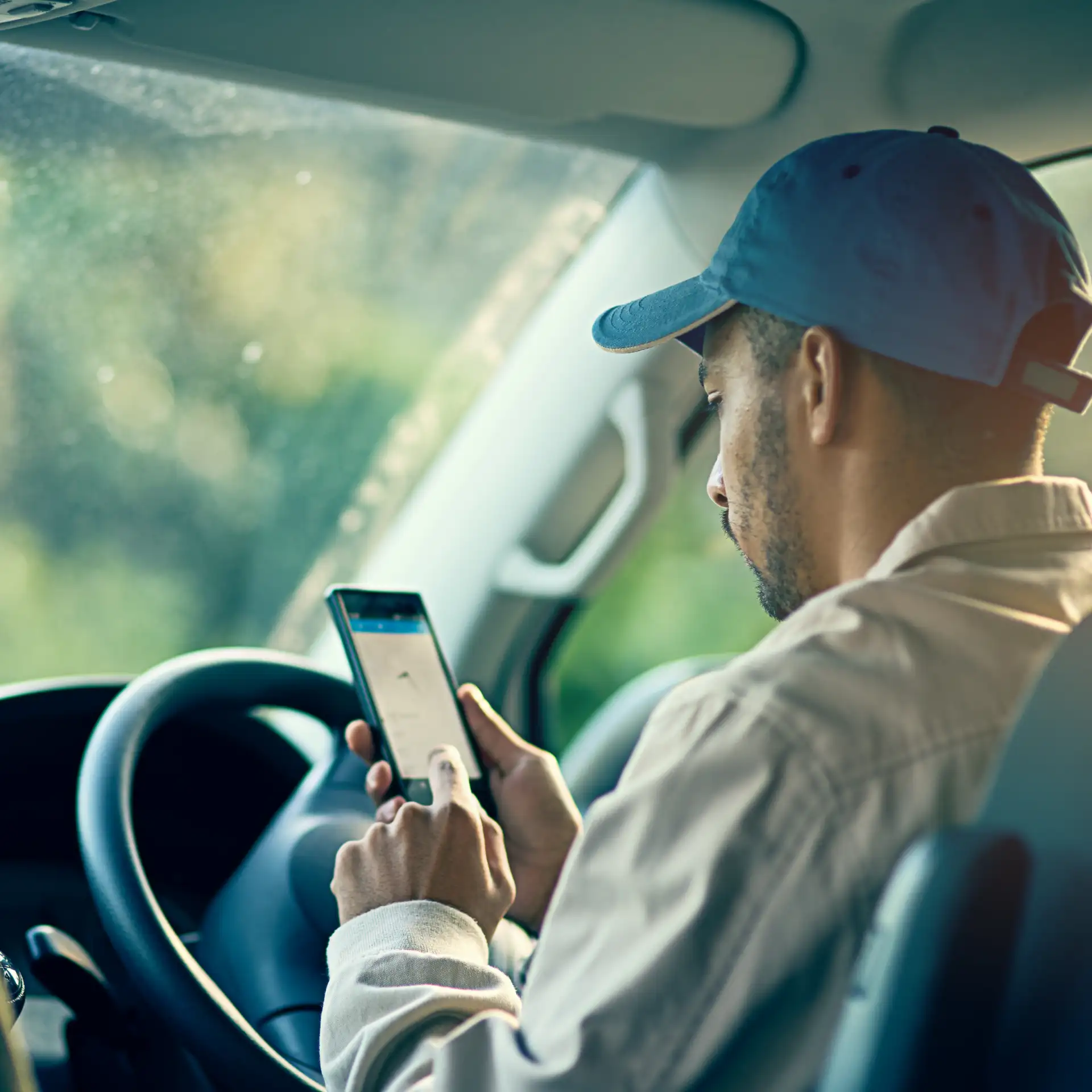 Man in vehicle looking at his phone
