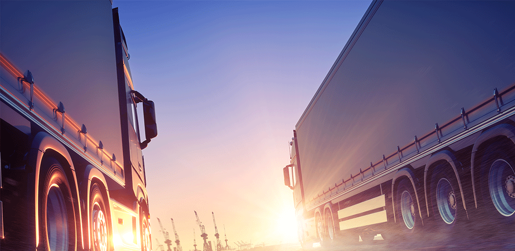 two lorries driving towards sun