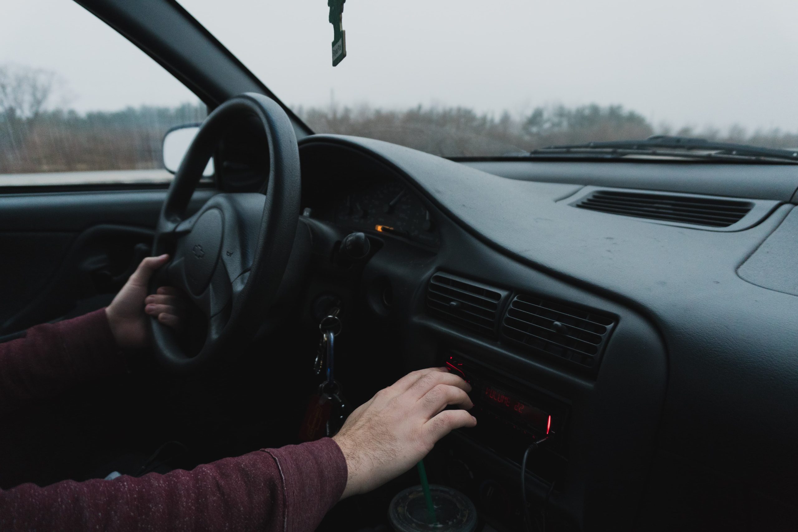 Person in car with hand on steering wheel